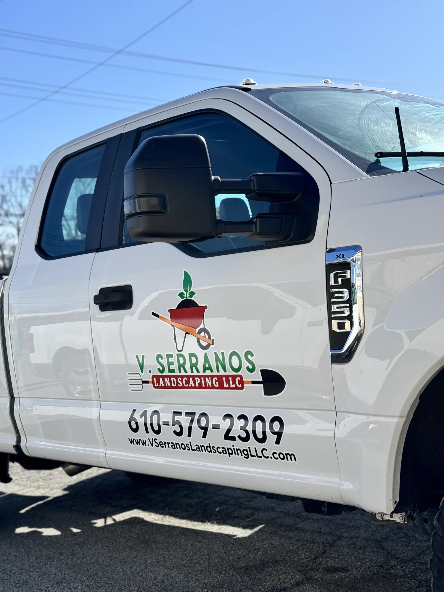 Full-color door logo and contact lettering for V. Serranos Landscaping on a Ford F-350 work truck